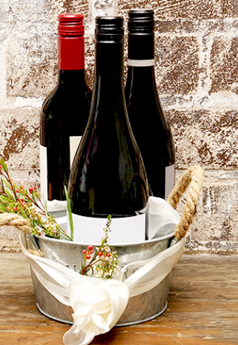 Decorated wine bucket containing three bottles of wine